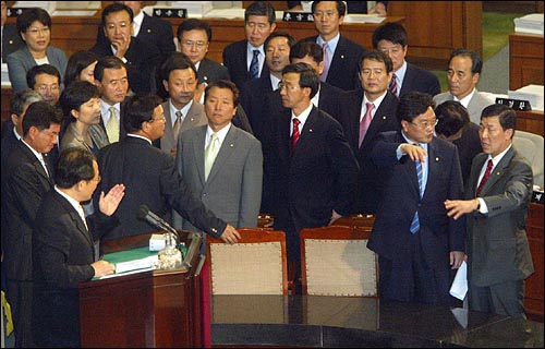 30일 밤 국회 본회의에서 정부조직법 수정안 찬성발언을 하던 김성곤 열린우리당 의원과 이에 반대하는 황진하 한나라당 의원(맨오른쪽)이 논쟁을 벌이고 있다. 